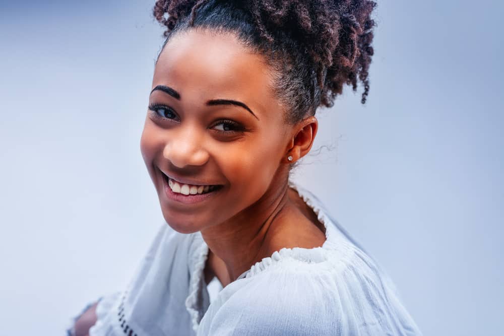 Young African American female wearing a semi-permanent hair color on her bleached hair cuticles.