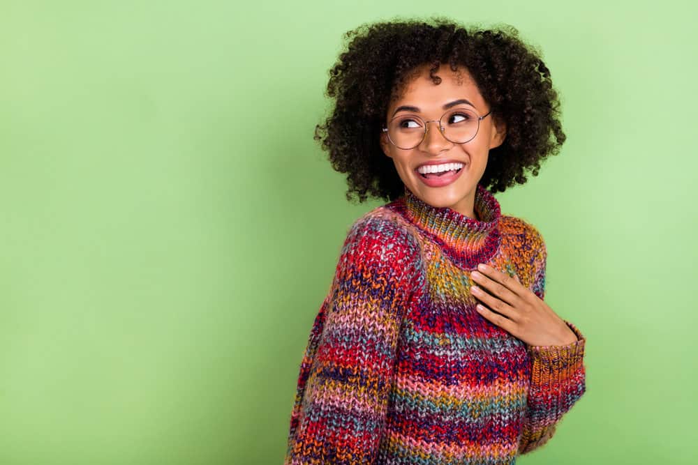 An African American female showing off her natural hair after permanent hair dye penetrates her dark brown strands.