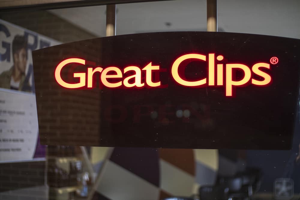 Neon window sign shown at night, where the Great Clips prices are shown on the left of the sign.