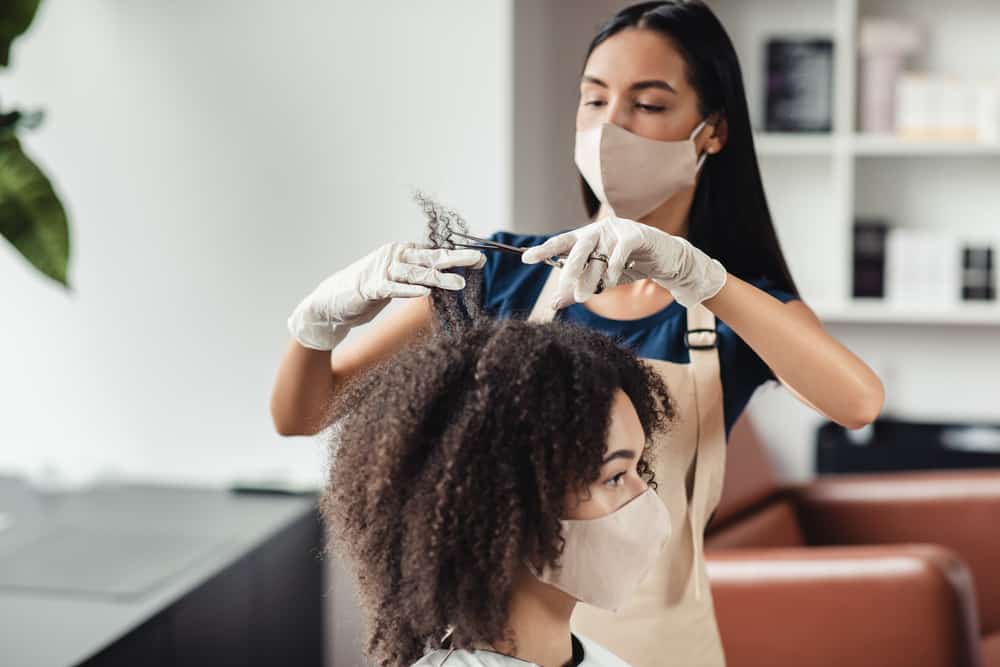 Beautiful adult female in a Walmart hair salon getting a hair cut before foil highlights and other color treatments.