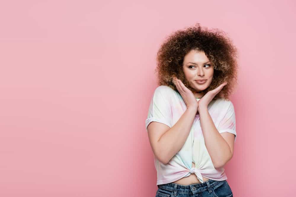 A white lady wearing a tie-dye t-shirt with a kinky wash and go afro-like hairstyle on type 4 white girl hair.