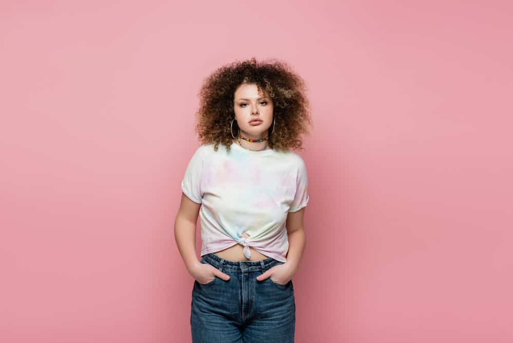 Mixed race lady wearing an afro hairstyle - like Bob Ross - on should length hair strands.