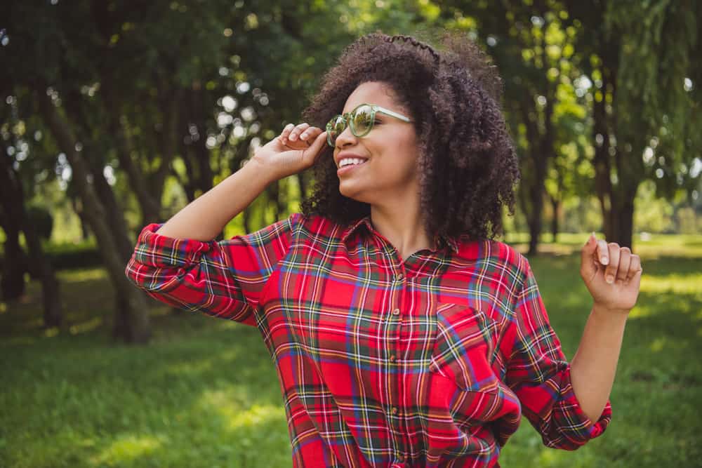 Cute African American female with a 4A curl pattern wearing a layered haircut and a casual outfit.