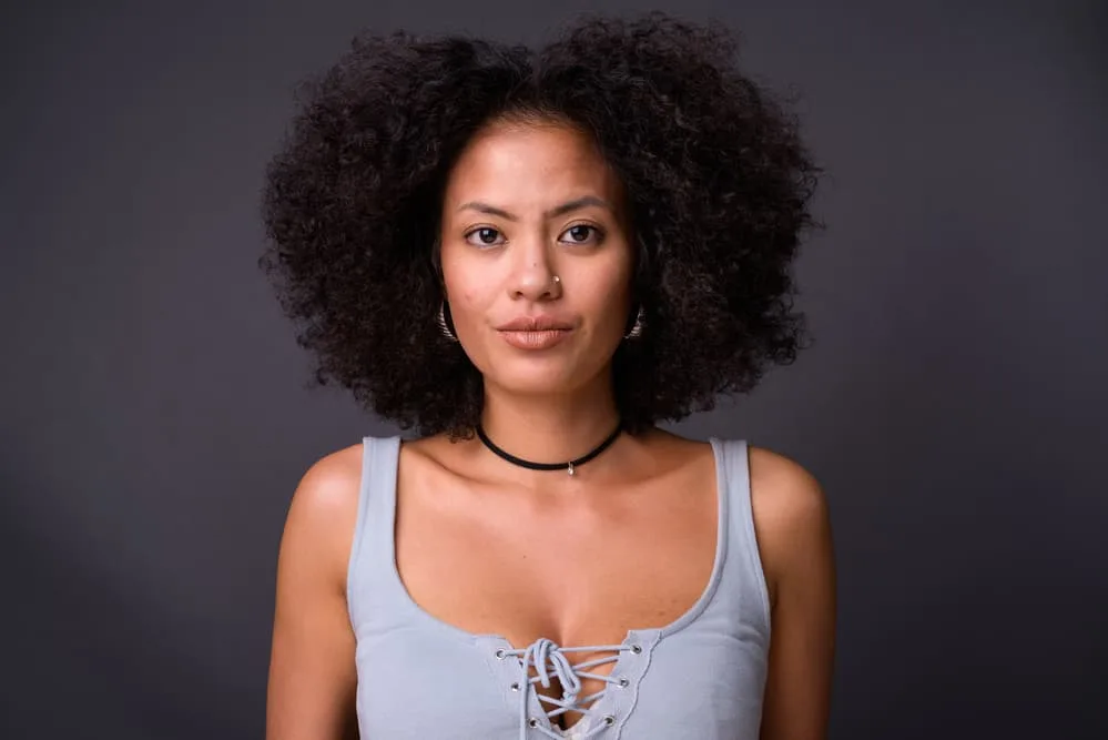 How Long Does It Take For Roots To Grow Out: Growing Out Natural Hair Color 2 Young multi-ethnic African American woman with healthy hair trimmed into a wolf-cut hairstyle.