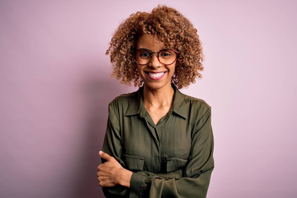 African American female with a reddish-brown hair color after using a semi-permanent hair dye on her natural curls.