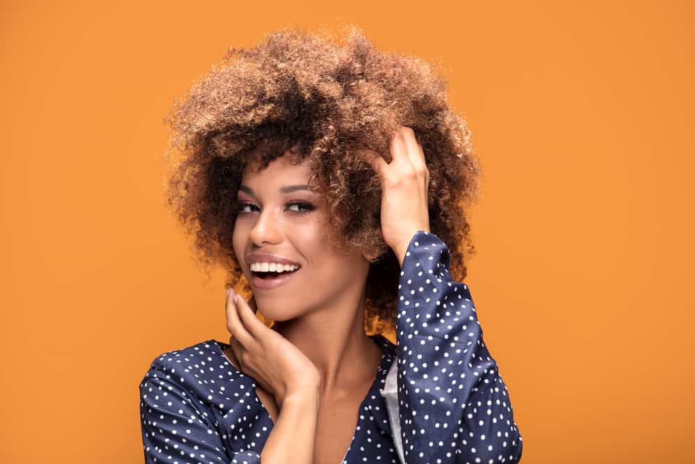 Beautiful African American female wearing a semi-permanent hair color on bleached hair strands.