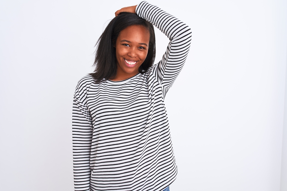 An adult female wearing her dry hair straight after it was styled with a ceramic flat iron and her natural oils.