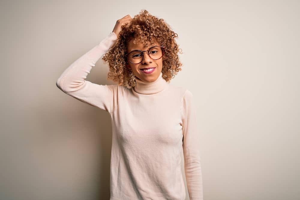 Young adult female with split ends after adding hair dye to her hair care routine that includes normal heat styling.