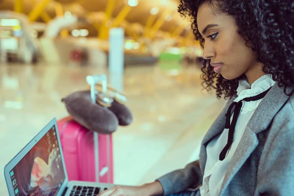 Cute black woman with curly hair researching TSA's rules around spray paint and solid deodorant.