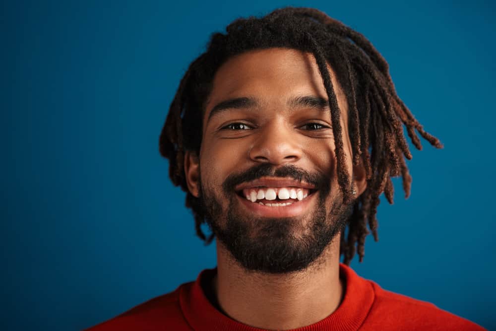 Young African man with naturally dark hair with light brown hair dye on his dyed dreadlocks.