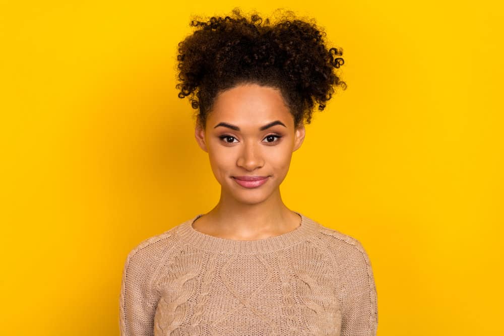 Adorable young black woman with curly hair after taking hair growth supplements for several months.