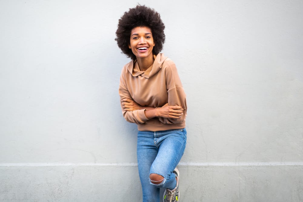 A black lady wearing casual clothes and a wash-and-go hairdo created with a wide-tooth comb.