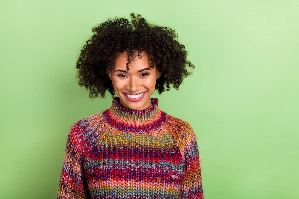 A cute black female with healthier hair after she stopped using harsh chemical processes on her natural curls.