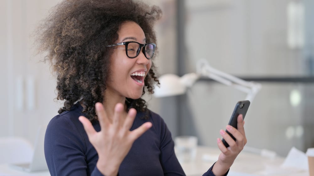 A girl with beachy waves researching how much a pin-straight hair cut costs to do at a professional stylist.