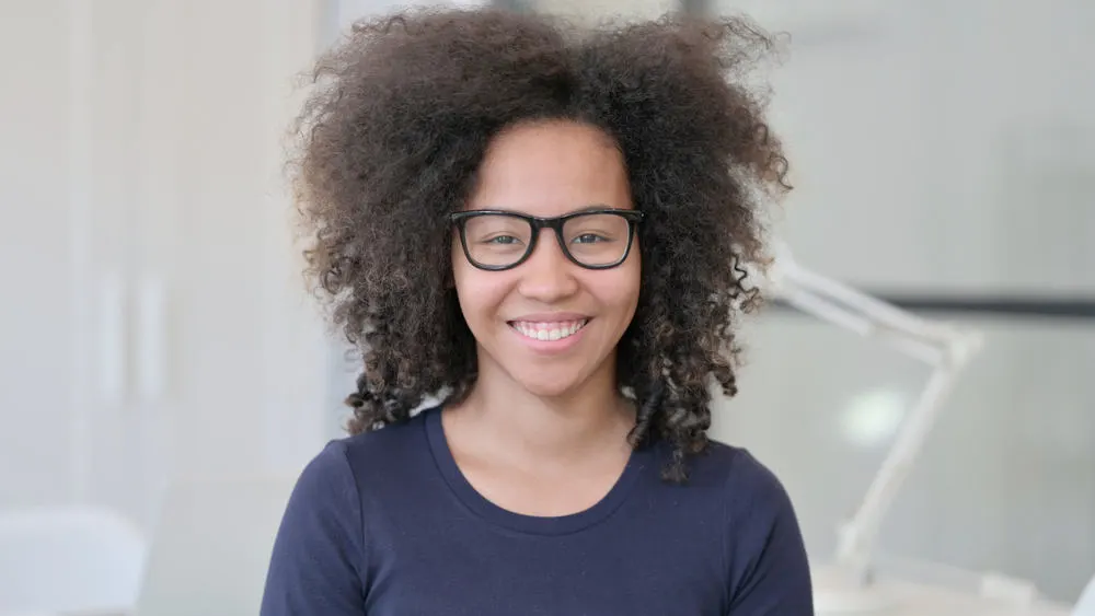 The Best Haircuts and Hairstyles for Women with Curly Hair 41 Cute African American female with a voluminous wolf haircut and an oval face shape styled with curl cream.