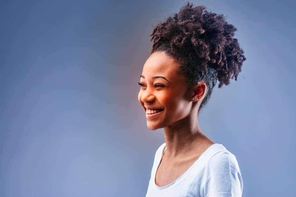 Young black woman with a great smile wearing her dark hair with reddish tips from purple color pigment.