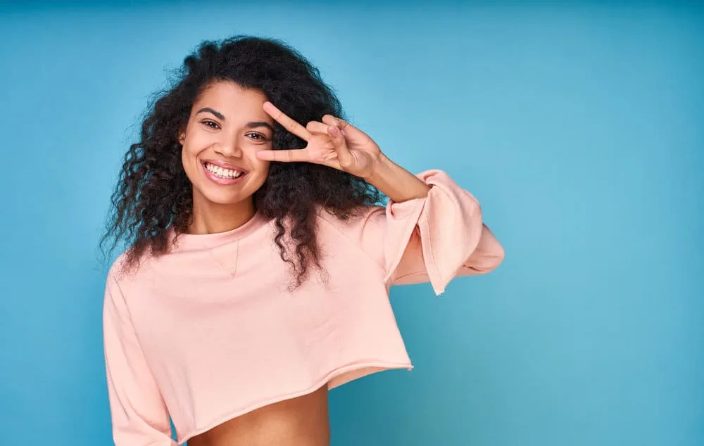 5 Best Products for Fine Wavy Hair: Shampoo, Oil, Gel, & More 16 An attractive young black female with a natural wave pattern after allowing her wet hair to air dry.