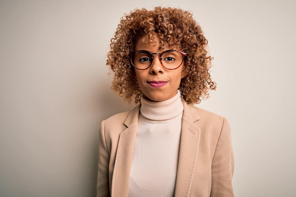 Black girl wearing color-treated curls after just a few washes and cotton candy pink lipstick with subtle facial makeup.