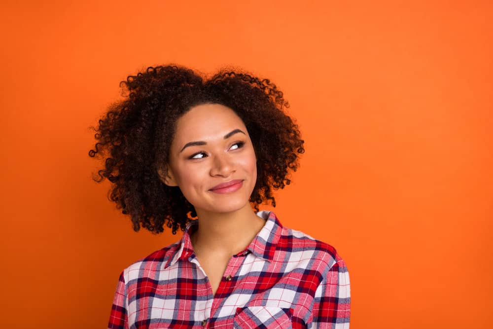 Sweet young female wondering if she has hair follicle damage after coloring her curls to avoid gray hair.