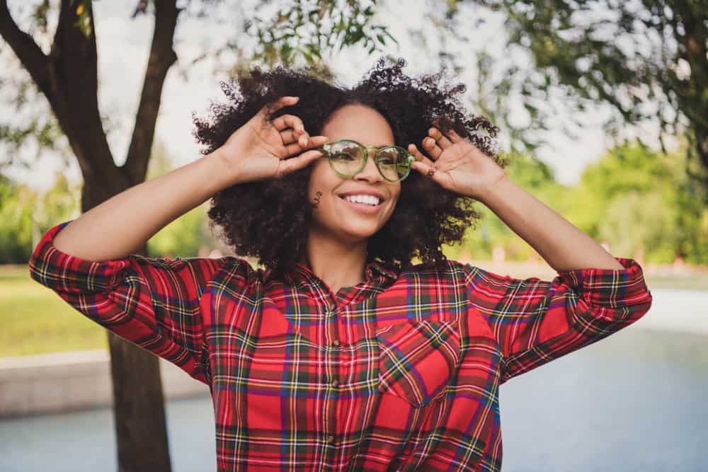 Young black lady with a shoulder length hairstyle - an ideal look for her triangular chin.