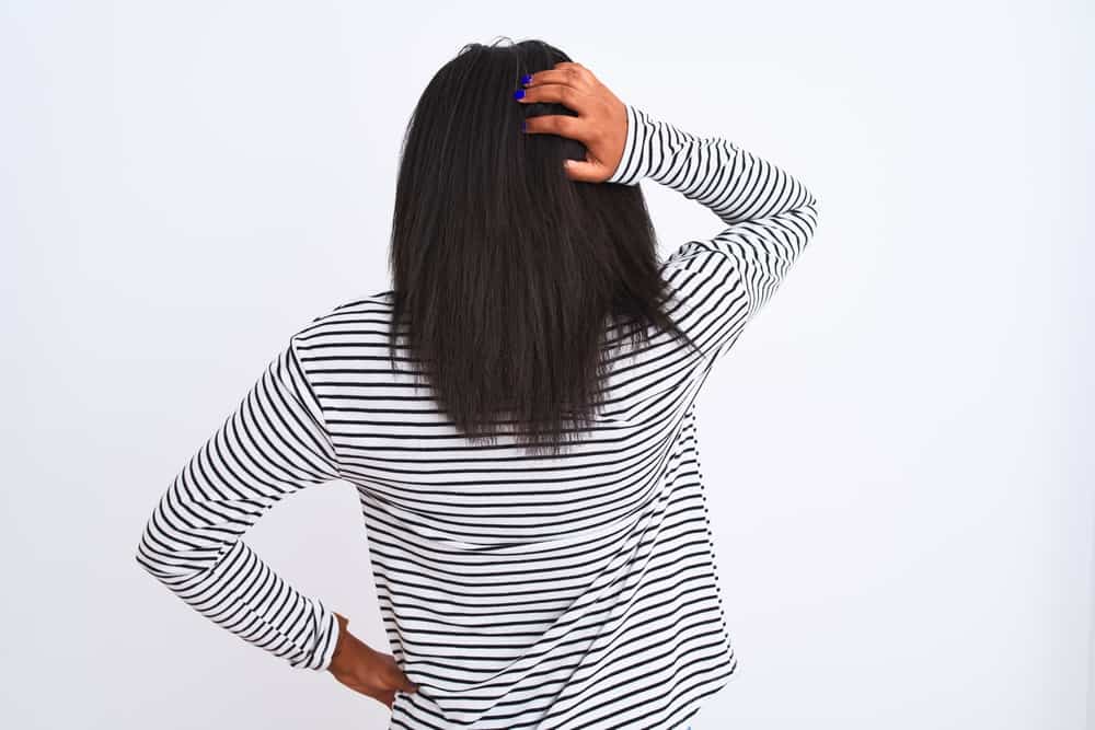Beautiful young African American girl showing off her bra-length hair after completing the straightening process.