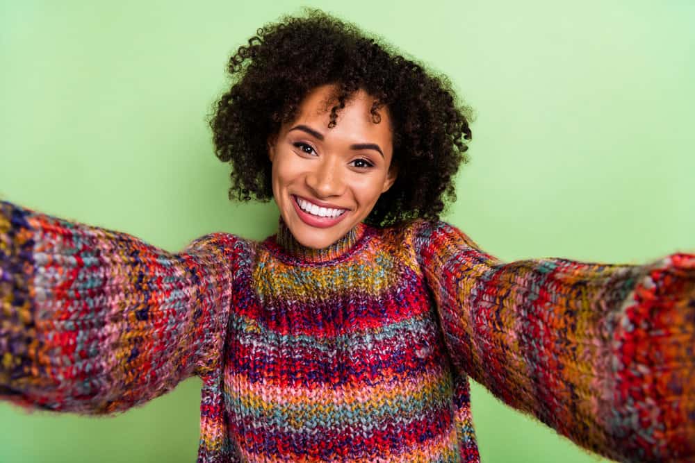 Millennial female with a dark brown natural color on her type 4A curly hair strands.