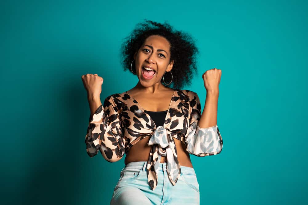 Black girl with her hair flicking outwards after treating her curls with hair masks and other moisturizing style products.