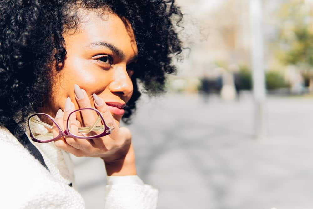 Black female wearing her hair lighter after using dark brown hair dye to cover her natural roots.