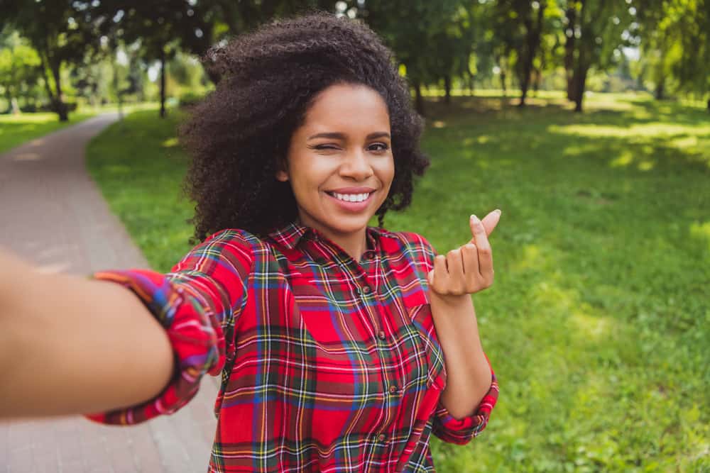 Young black girl with curly long hair that compliments her triangular shape face.