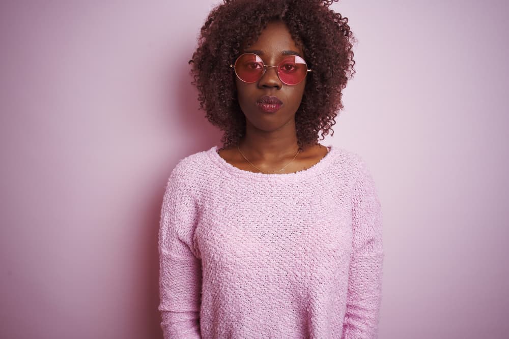 Young African woman wearing a wig made from either human or synthetic hair fibers covering her original hair.