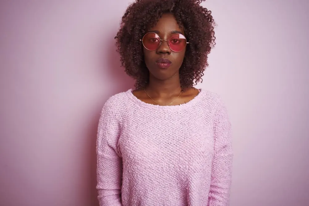 Weaves vs Wigs Debated: Which Is Better a Wig or Weave? 3 Young African woman wearing a wig made from either human or synthetic hair fibers covering her original hair.