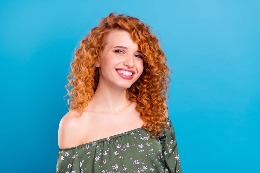 Lovely lady with a pale skin tone wearing dyed hair with neutral facial makeup and red lipstick.