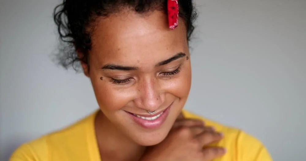 Young mixed race female with a great smile wearing a thick headband design to protect her curls at night.