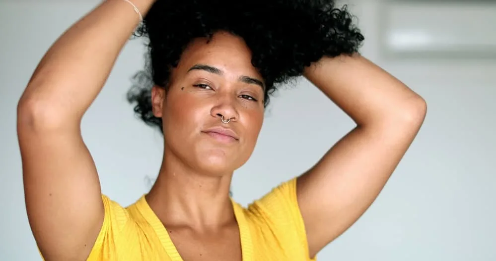 How to Put on a Bonnet on Curly Hair and Straight Hair 6 Young African American girl after drying her wet hair putting her curls in a pineapple updo as she prepares for bed.