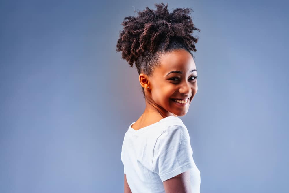 African American female with brassy hair after using blonde hair dye wearing a wash n go style.