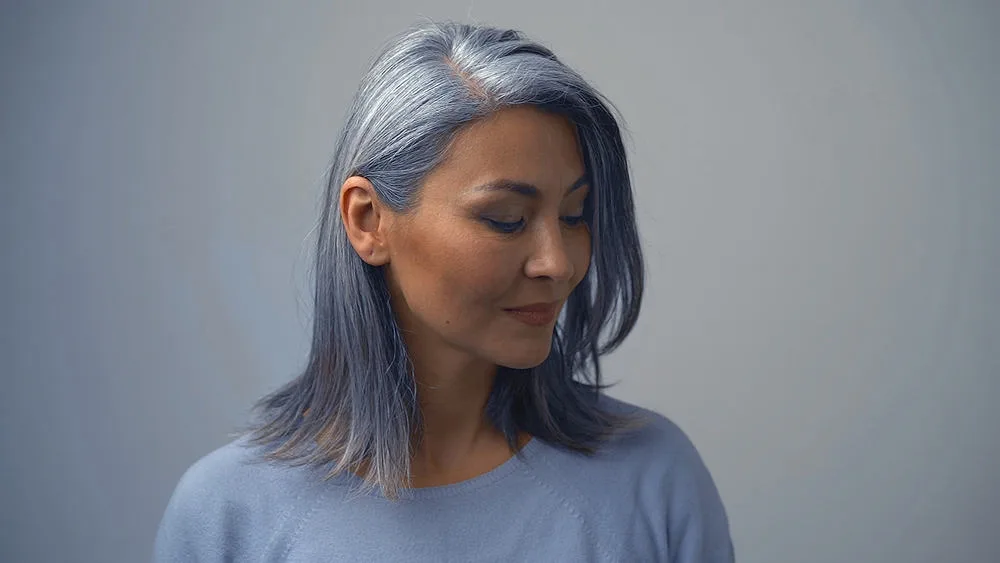 Removing Hair Color to Go Grey at Home: DIY How-to Guide 4 Beautiful senior female with natural grey hair showing off her hair after removing permanent hair dye.