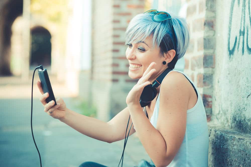 Young beautiful female after dyeing her hair blue with a vibrant blue hair dye creating a pastel blue look.