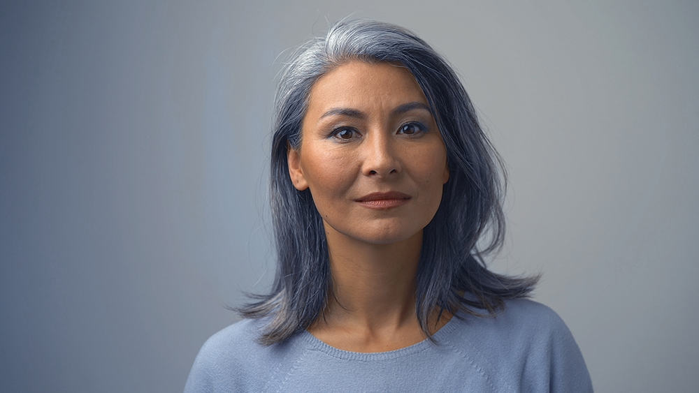 Asian female with semi-permanent dye on dark hair wearing red lipstick and subtle make-up.