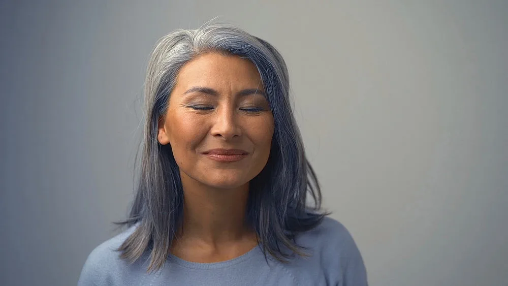 Removing Hair Color to Go Grey at Home: DIY How-to Guide 3 A charming Asian lady with her hair dyed is wanting to remove permanent hair dye to show off her silver hair.