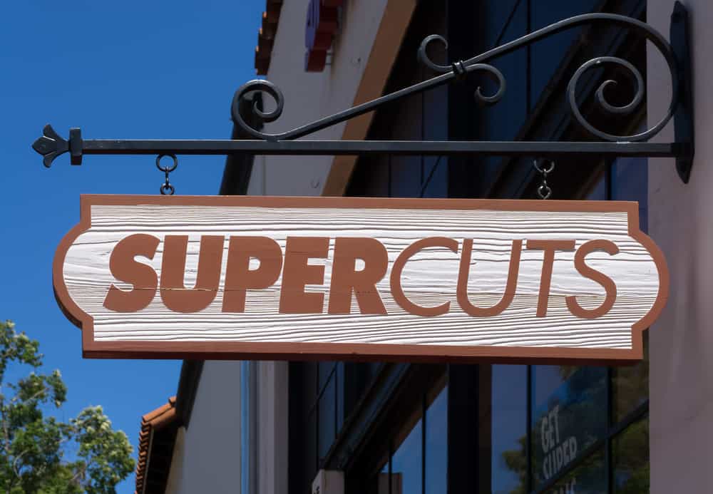 The business brand, Supercuts services, and actual pricing information are prominently displayed near the storefront.
