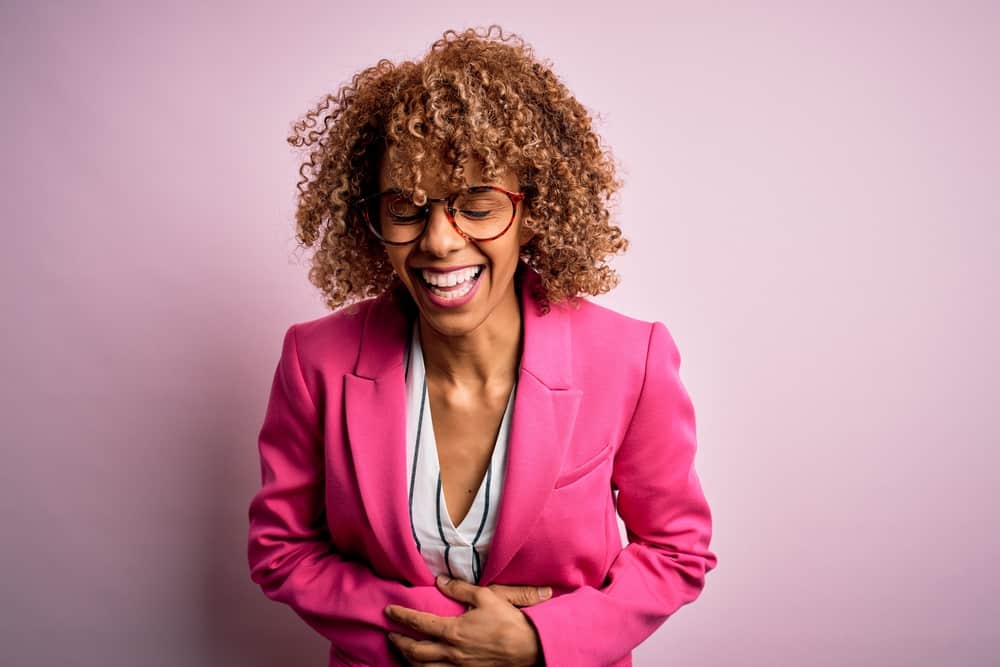 Businesswoman with light brown curly hair strands after mixing conditioner with semi-permanent hair dye.