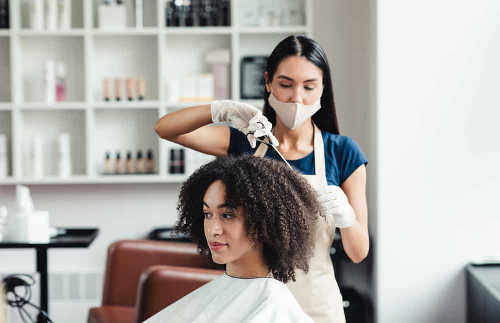 African American female with a curly hair type getting an express hair cut within a Walmart hair salon.