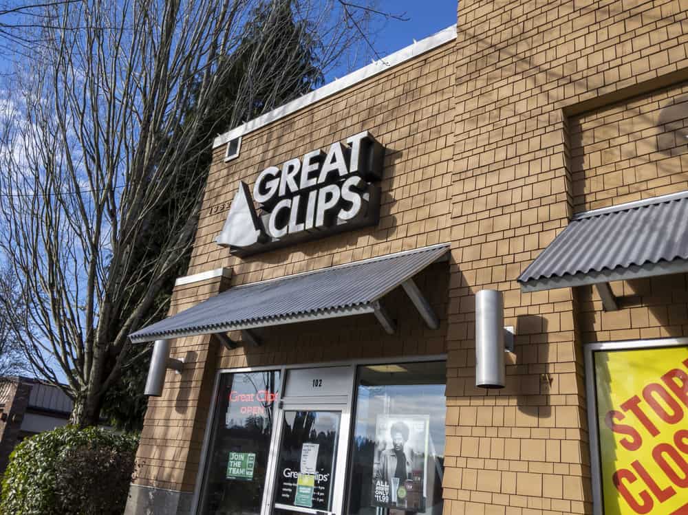 Great Clips hair salon building with brown bricks and a bright red open sign.