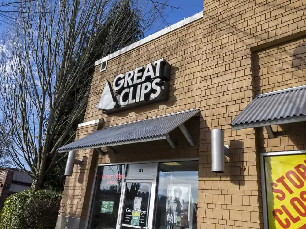 Great Clips hair salon building with brown bricks and a bright red open sign.