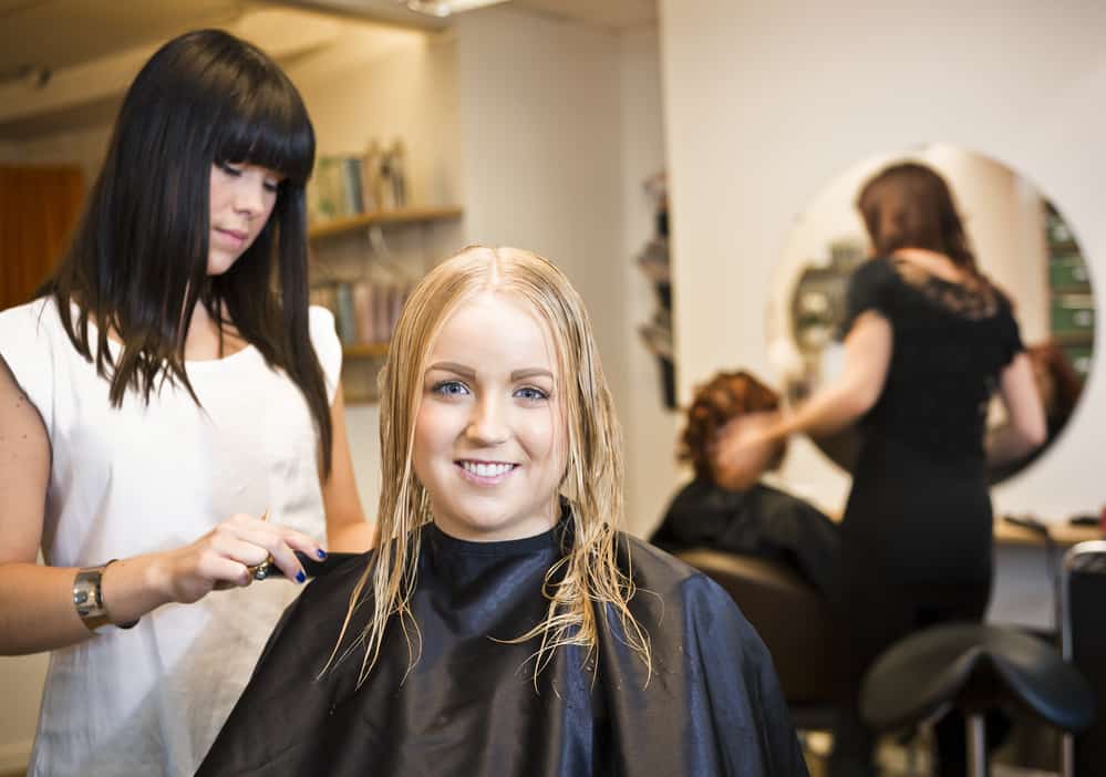 White girl with medium hair length getting a shampoo service and a quick trim.