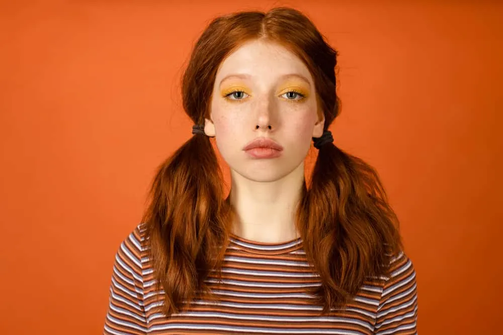 How to Fix Orange Hair With Box Dye: DIY Step-By-Step Guide 3 Young women with brassy orange natural hair color wearing bright orange eye shadow and striped shirt.