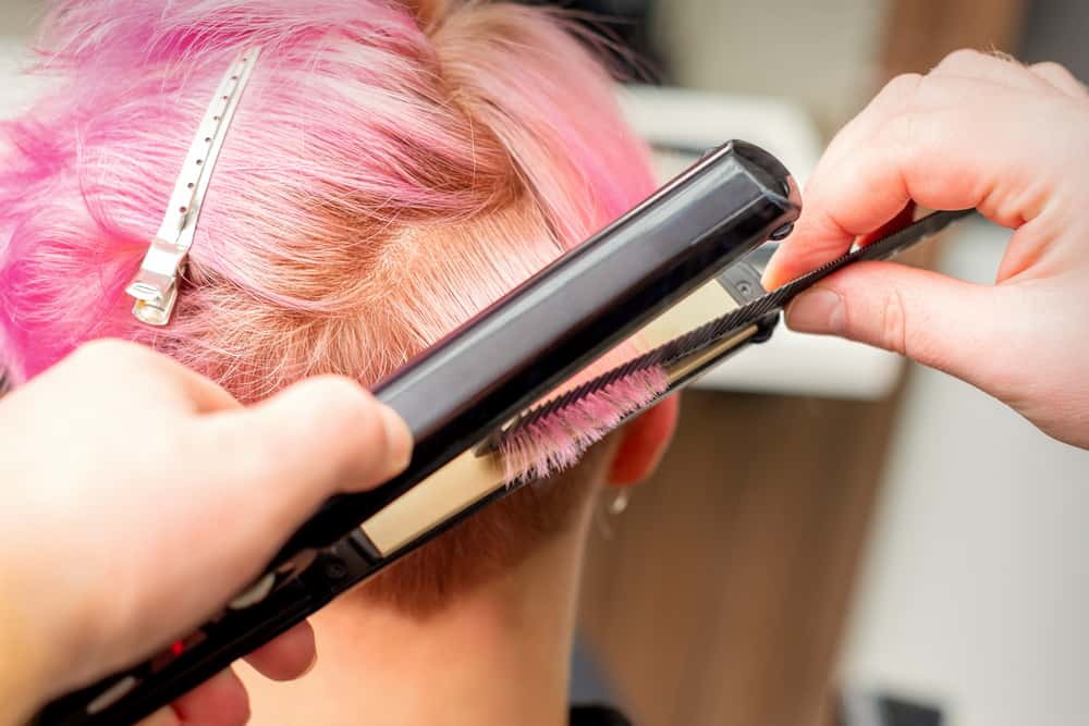 One of Mastercuts hairstylists in a family-friendly salon undergoing heat styling hair treatments.