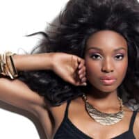 Cute African American female with coarse hair posing after removing armpit hair on dark sensitive skin.