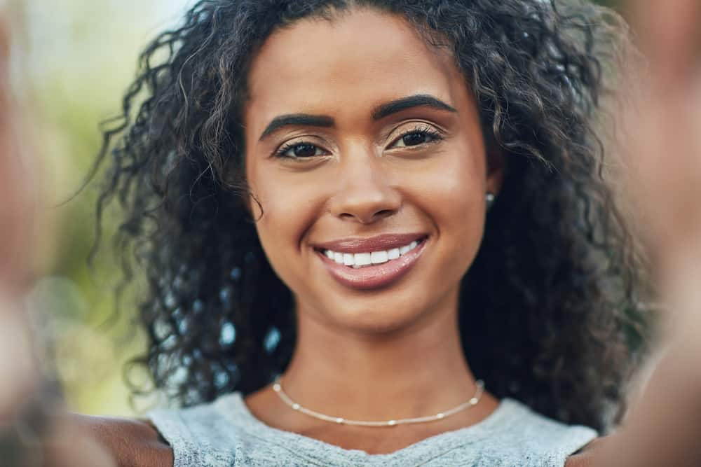 Attractive young African American woman with a fine hair type styled using the curly girl method.