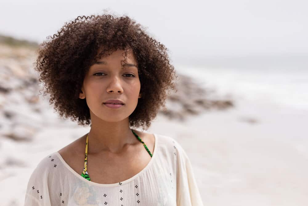 African American female with naturally wavy hair feels dry after swimming in the ocean and enjoying the natural waves.